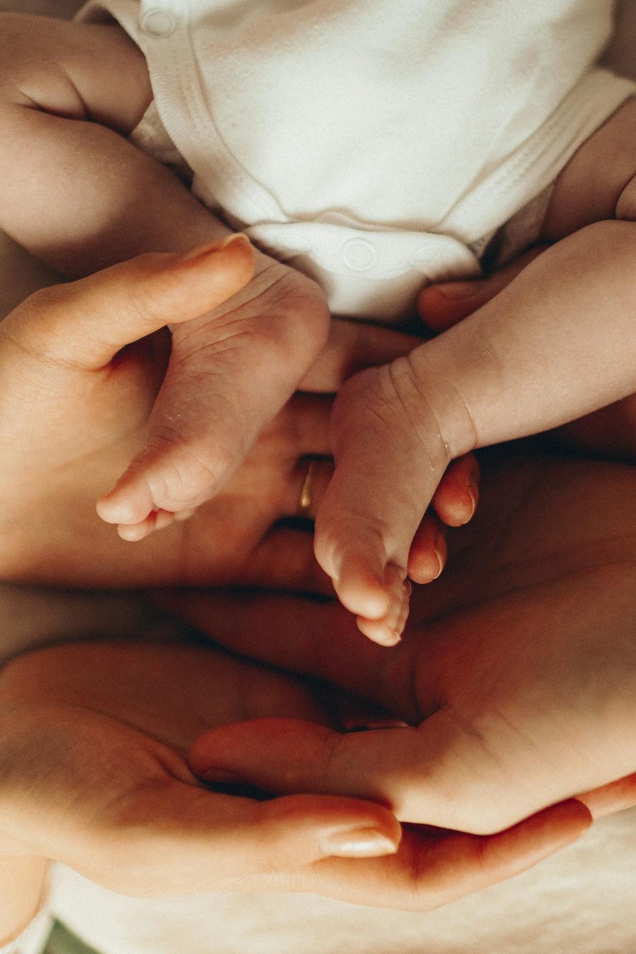 Mother cradling a newborn baby - warm tones representing reproductive health.